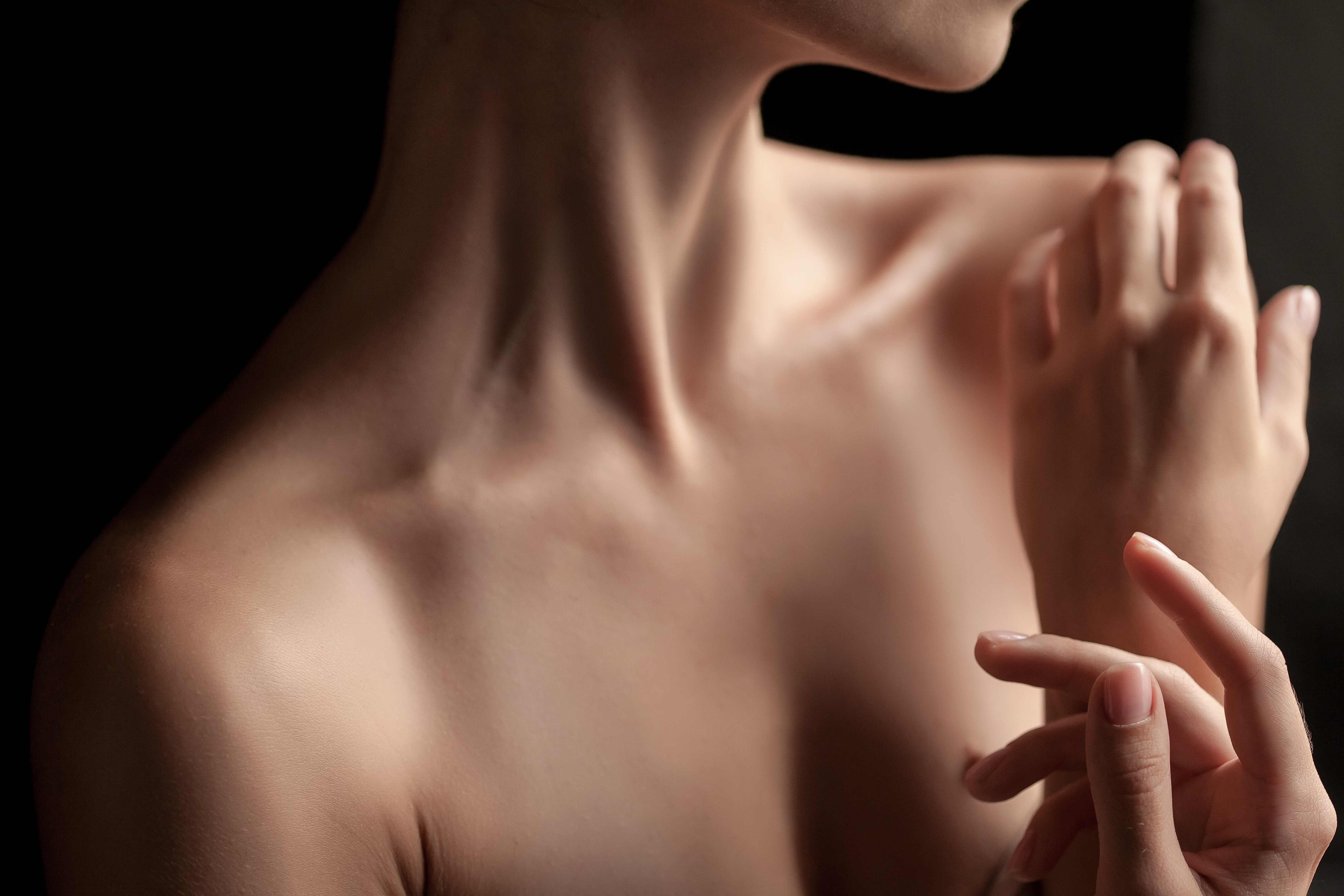 close up young woman s neck hands dark background 3c604