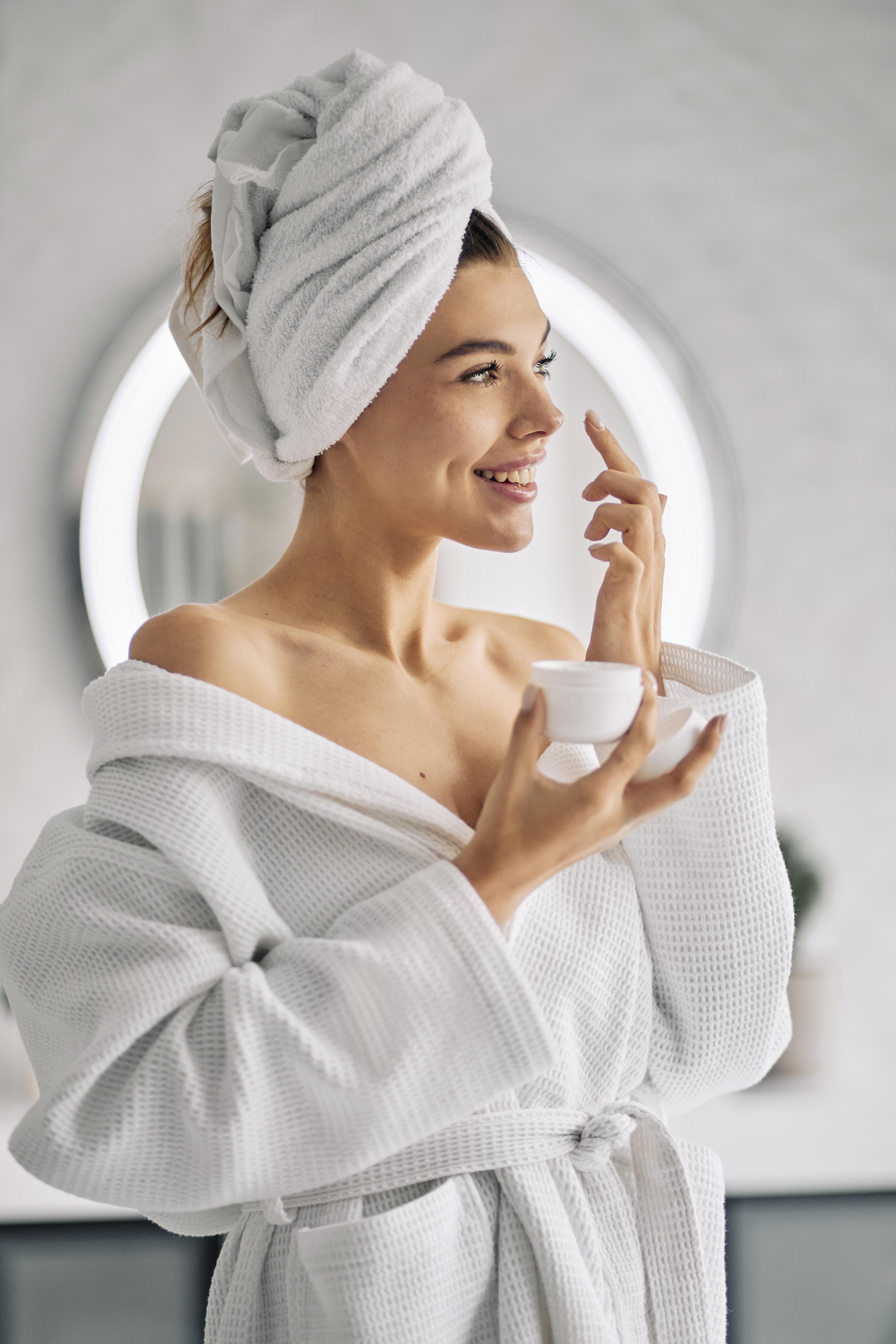 smiley woman holding skincare cream a0d9a